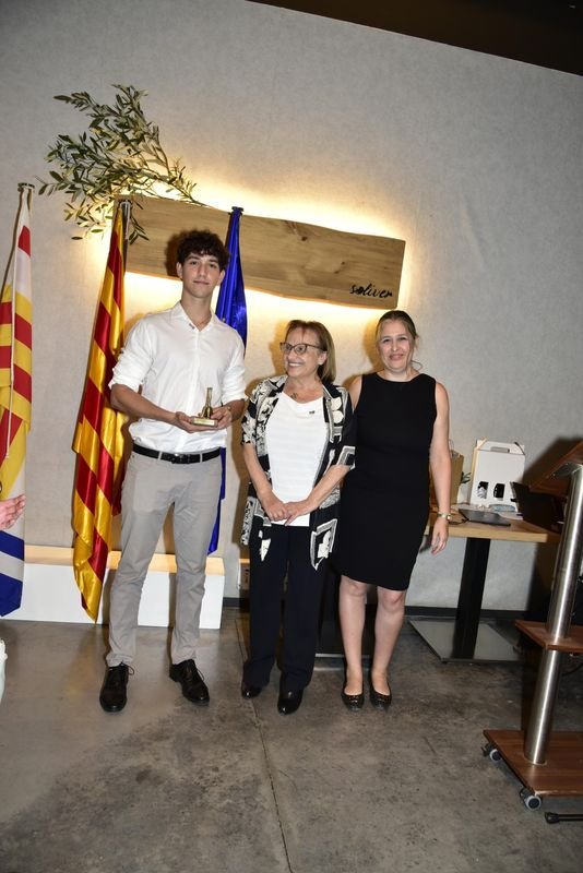 Un soci de Rotaract Igualada sosté la campana del club, acompanyat de dues dones